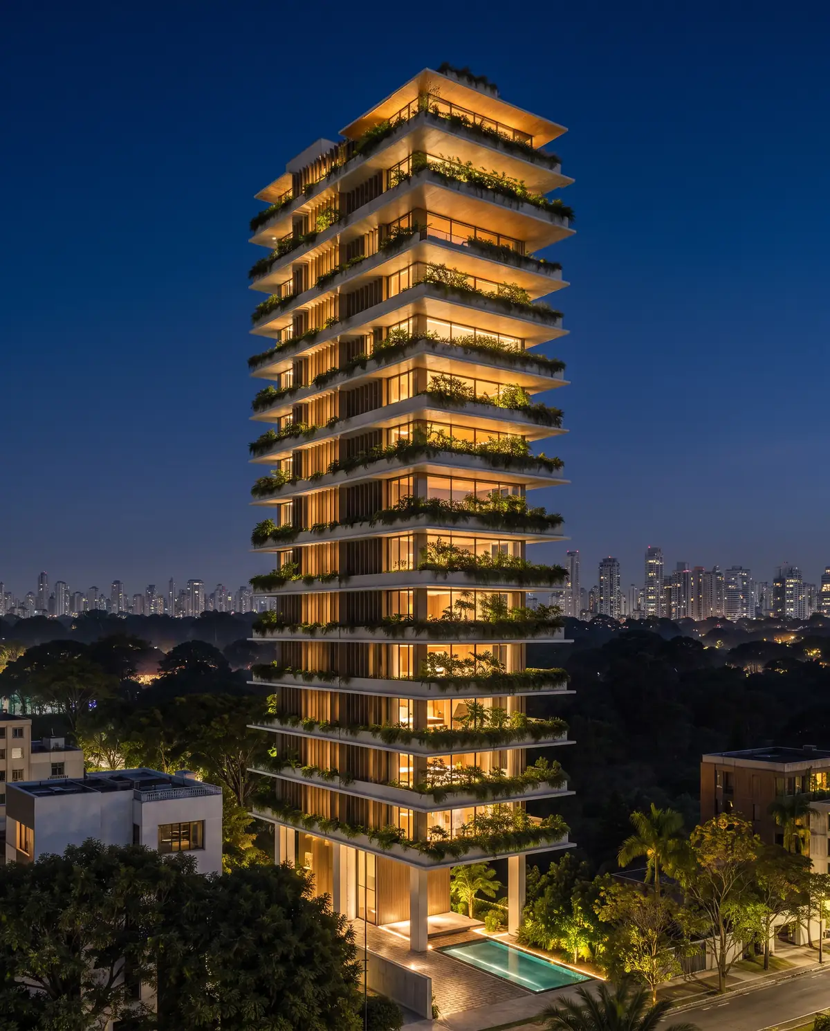 A torre ALVOR à noite, com os andares iluminados e os jardins suspensos acesos